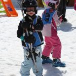 5 year old carrying his skis